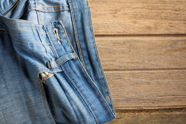 jeans stacked on a wooden background - Photo, Image