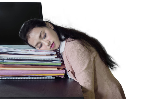 Ładna kobieta wygląda zmęczony podczas snu powyżej stos dokumentów, izolowana na białym tle - Zdjęcie, obraz