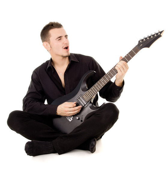 un joven vestido con ropa negra se sienta y toca la guitarra
 - Foto, imagen
