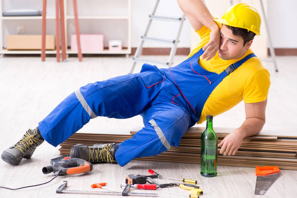 Floor repairman drinking alcohol during break - Fotó, kép