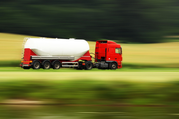 Большой белый цистерна грузовик, мчащийся по шоссе
 - Фото, изображение