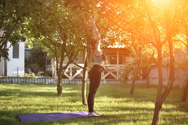 Mulher grávida no jardim pratica ioga, cumprimentando o sol. Manhã de verão
. - Foto, Imagem