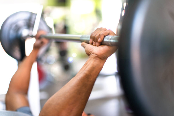 Деталь сильного красивого спортивного чоловіка, що робить важку атлетику в спортзалі
 - Фото, зображення