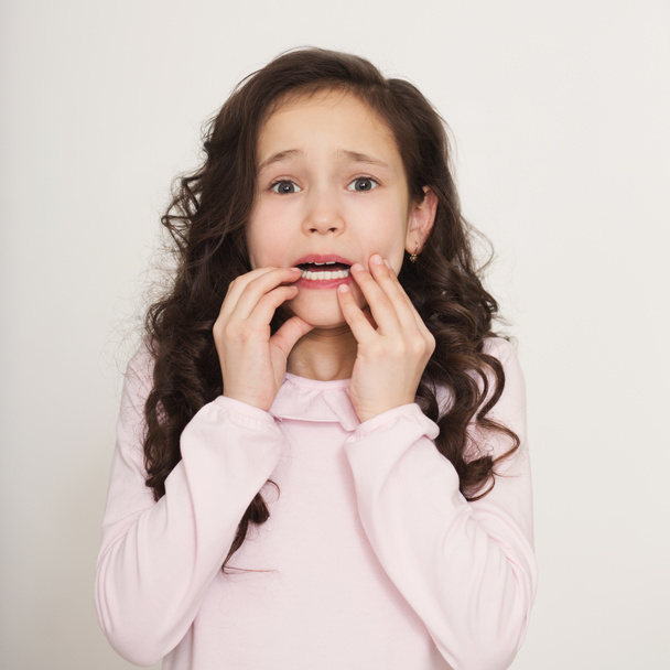 Little nervous girl biting her finger nails - Foto, Imagen