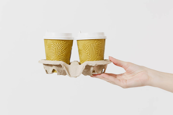 Detailní záběr žena drží v ruce dvě s sebou šálek kávy nebo čaje v jasné prázdné prázdné kartonové hnědé držáku, izolované na bílém pozadí. Dodávka služby koncept. Kopírovat prostoru. Reklamní plocha - Fotografie, Obrázek
