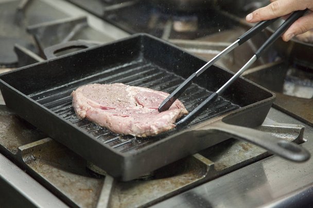 Hands cook cooking beef in a frying pan Close-up - Foto, afbeelding