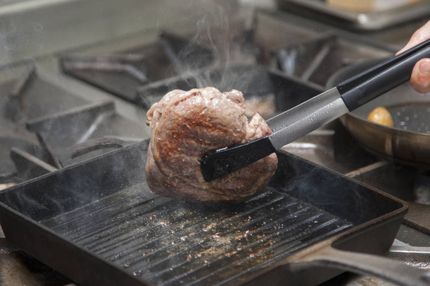 Hands cook cooking beef in a frying pan Close-up - Fotó, kép