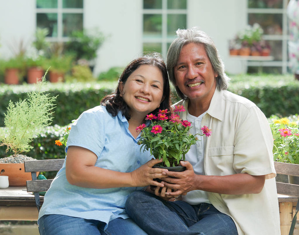 Senior couple laughing together in home garden. - Foto, imagen