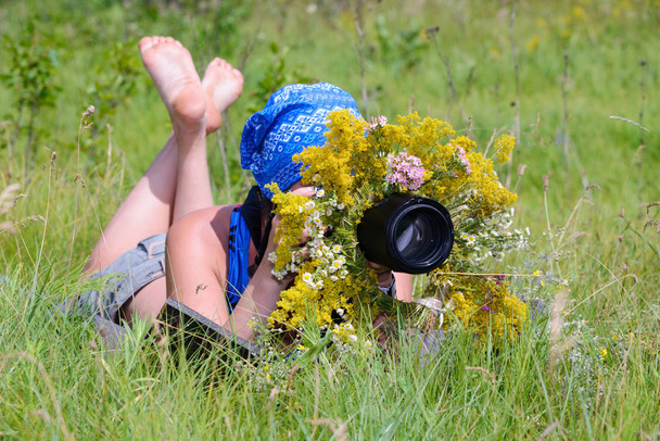 Дівчина-фотограф-мисливець. Маскування для фотографування тварин в зеленій траві в сонячний день
. - Фото, зображення