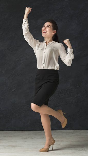 Femme excitée célébrant le succès, dansant en studio
 - Photo, image