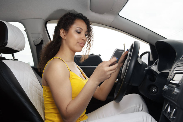 Motorista jovem usando smartphone touch screen e navegação gps em um carro. - Foto, Imagem