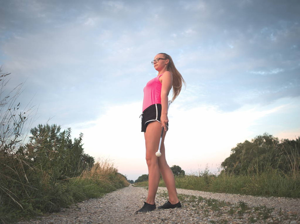 Bespectacled Blonde Adolescente Majorette Fille Tourbillonnant Baton En plein air dans Vêtements d'entraînement
 - Photo, image
