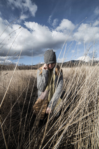 Жінка в сухому пшеничному полі з очима вкрита сірою шапочкою
  - Фото, зображення