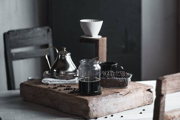кофе В стеклянной бутылке, кофе капельницы, Рука держа чайник Капельный кофе В номере, черный кофе в стекле
 - Фото, изображение