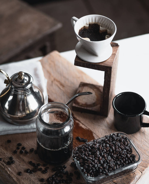 кофе В стеклянной бутылке, кофе капельницы, Рука держа чайник Капельный кофе В номере, черный кофе в стекле
 - Фото, изображение
