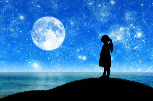 Silhouette, little girl child standing on a hill by the sea looking at the starry sky. Conceptual image of children's dreams - Foto, afbeelding