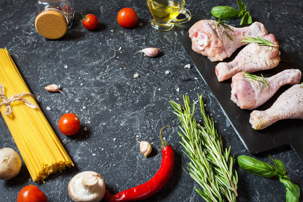 パスタの食材。鶏足のモモ肉、チェリー トマト、スパゲティ、石のテーブルにキノコ。本文スペース平面図. - 写真・画像