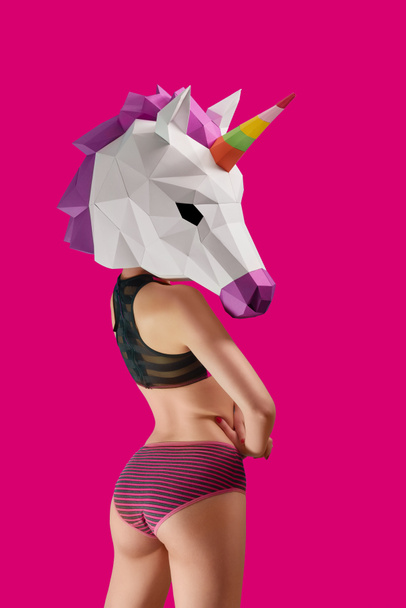 Saturated photo of girl wearing stripped pink panties and unicorns mask. - Foto, Imagem