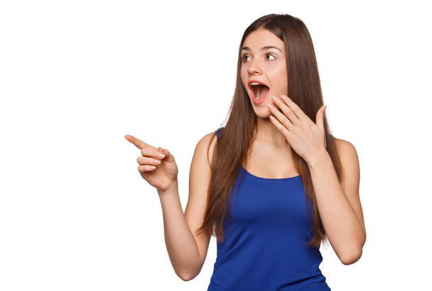 Mujer excitada mostrando el dedo en el espacio de copia para producto o texto, aislado sobre fondo blanco
 - Foto, imagen