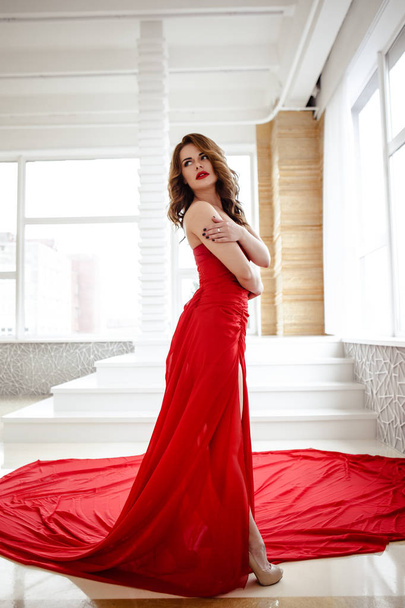 Krásná brunetka žena v červených šatech, módní portrét krása s make up a účes - Fotografie, Obrázek