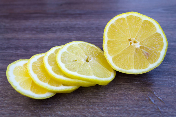 Tranches d'un citron coupé en gros plan sur une table en bois
 - Photo, image