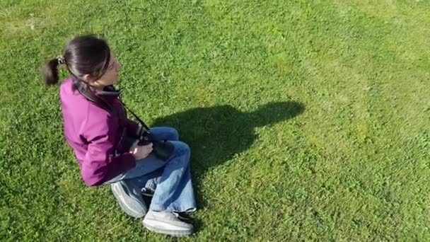 Female photographer using DSLR camera on grass - 映像、動画