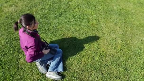 Fotografo femminile che utilizza la fotocamera DSLR sull'erba
 - Filmati, video