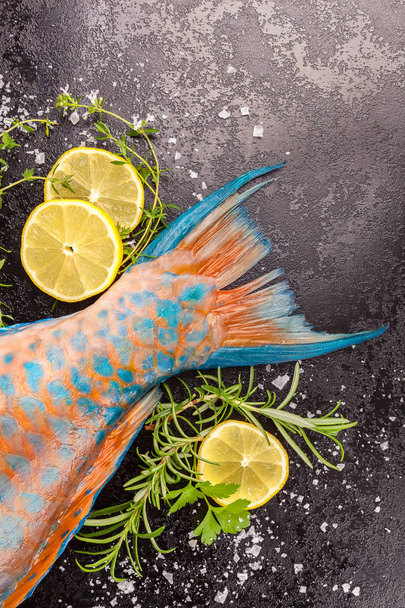 Tail of parrotfish from above with lemons and herbs. - Photo, Image