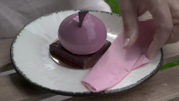 A close up of a cake eaten by a woman. A woman's hand takes a fork, moves away a napkin and slips off a piece of cake with the fork. - Filmmaterial, Video