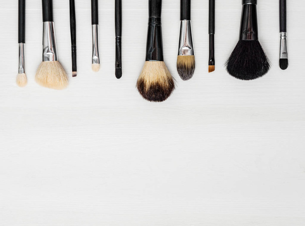 make-up brushes on a light wooden background - Φωτογραφία, εικόνα