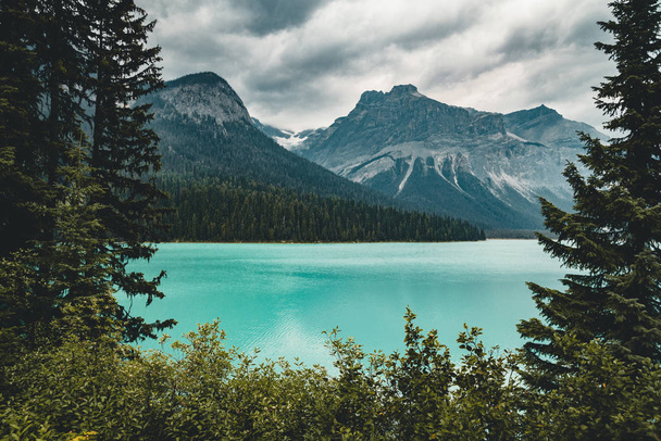 Σμαραγδένια λίμνη στον καναδικό Βραχώδη Όρη με βουνά και στη λίμνη και τα δέντρα. Έννοια της δραστήριες διακοπές και εκδρομές. - Φωτογραφία, εικόνα