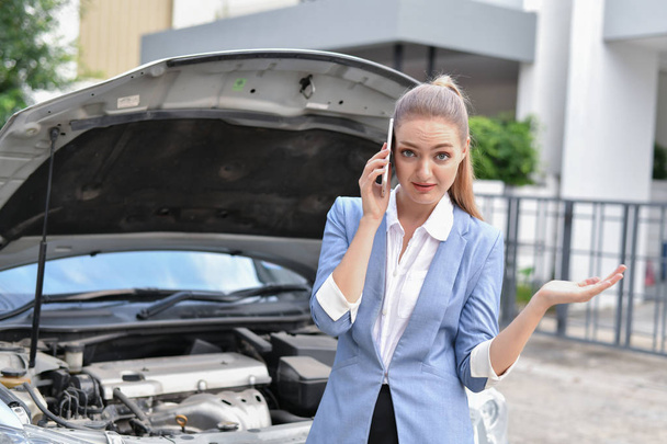 Driving Stress Concepts. Businesspeople are calling by insurance. Businesswomen are stressed because of broken car. - Foto, Bild