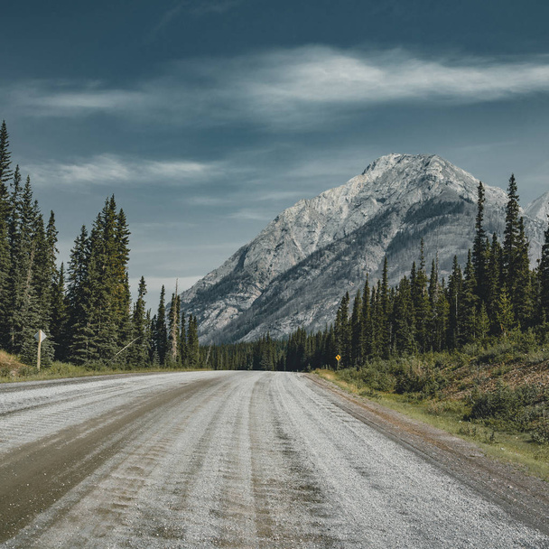 View of street highway with mountains and trees with blue sky and clouds. Banff National Park Canada Rocky Mountains. Photo taken in Canada. - Zdjęcie, obraz