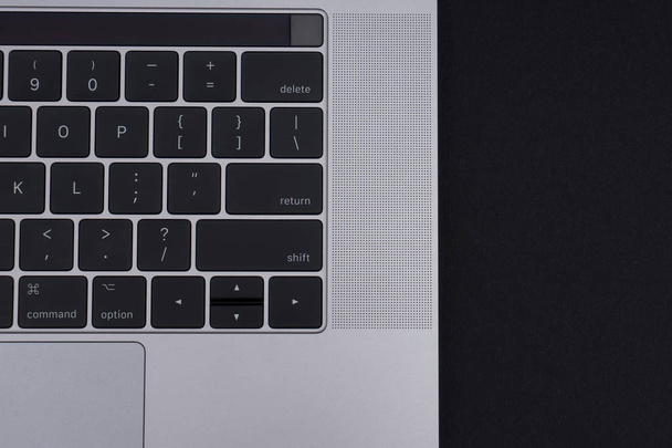Grey metal laptop on black background close up. View from above on keyboard and beautiful body. - Foto, Imagem