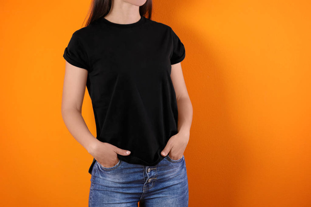 Young woman in black t-shirt on color background. Mockup for design - Photo, image