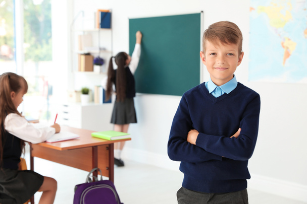 Little boy in classroom. Stylish school uniform - 写真・画像
