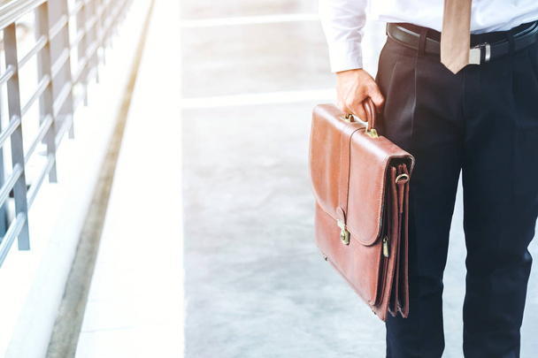 Businessman holding a briefcase travellers walking outdoors - Foto, Bild