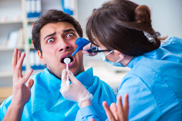 Patiënt bang voor tandarts tijdens doktersbezoek - Foto, afbeelding