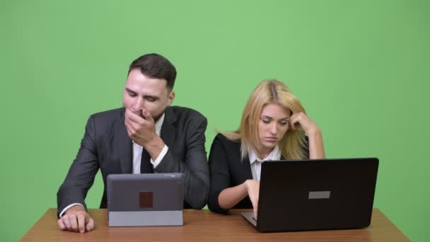 junges unternehmerisches Paar sieht gelangweilt aus, während es zusammenarbeitet - Filmmaterial, Video