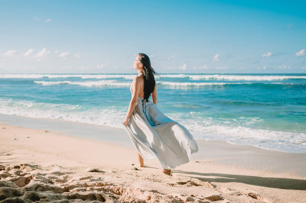 Портрет женщины в сером платье на пляже с закатом на рассвете
. - Фото, изображение