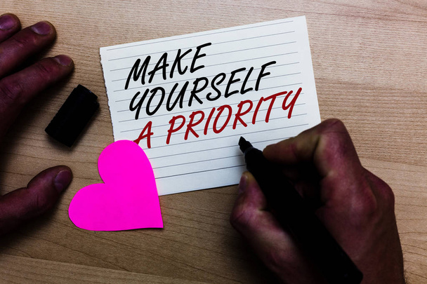 Handwriting text writing Make Yourself A Priority. Concept meaning Think in your own good first personal development Written on notepad hand hold marker with love heart wooden background - Photo, Image