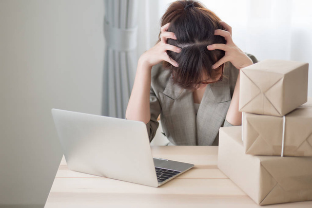 asian woman business owner working with stress and headache; portrait of sad stress unhappy business woman getting headache from business failure, loss, problem; adult asian chinese woman model - 写真・画像