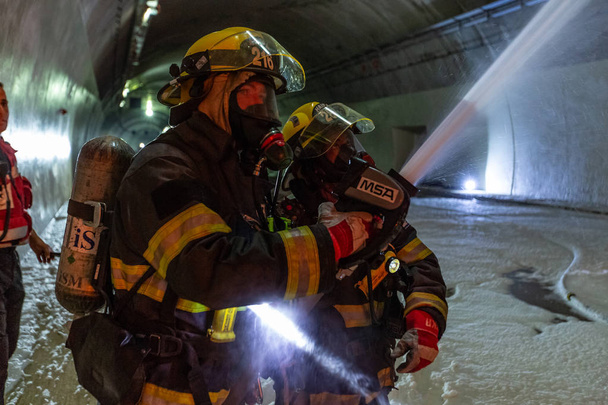 Car accident scene inside a tunnel, firefighters rescuing people from cars - Photo, Image