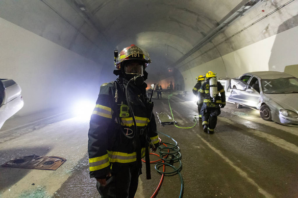 Cena de acidente de carro dentro de um túnel, bombeiros resgatando pessoas de carros
 - Foto, Imagem
