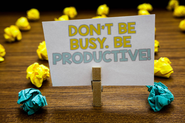 Writing note showing Don t not Be Busy. Be Productive. Business photo showcasing Work efficiently Organize your schedule time Written notepad stand with paperclip yellow blue lobs on wooden deck - Фото, зображення