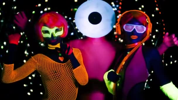Sexy women and man with record vinyl head in fluorescent clothing under UV black light. - Footage, Video