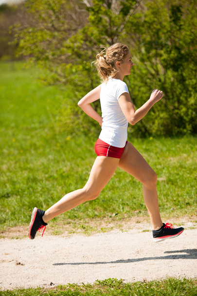 Woman runner runs - workout in spring. - Fotografie, Obrázek