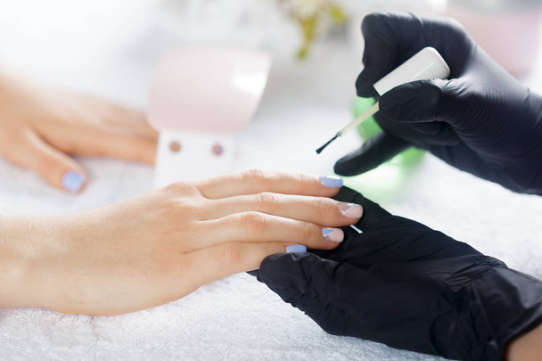 Woman hands receiving a manicure in beauty salon - Φωτογραφία, εικόνα