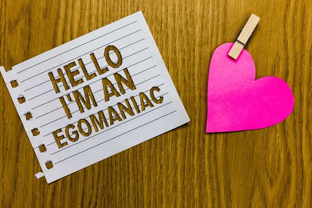 Conceptual hand writing showing Hello I am An Egomaniac. Business photo showcasing Selfish Egocentric Narcissist Self-centered Ego Yellow woody deck word with white page paper clip grip heart - Photo, Image