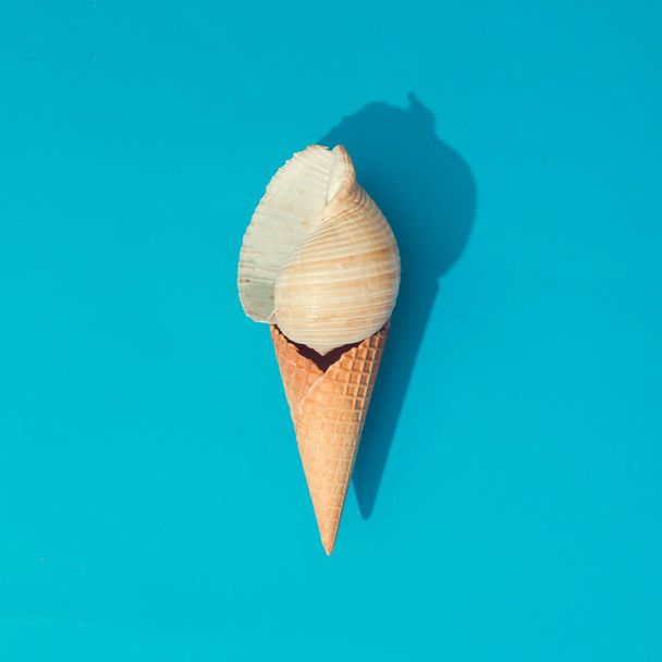 Rozložení kreativní léto s mušli a kornout zmrzliny na světle modrém podkladu - Fotografie, Obrázek